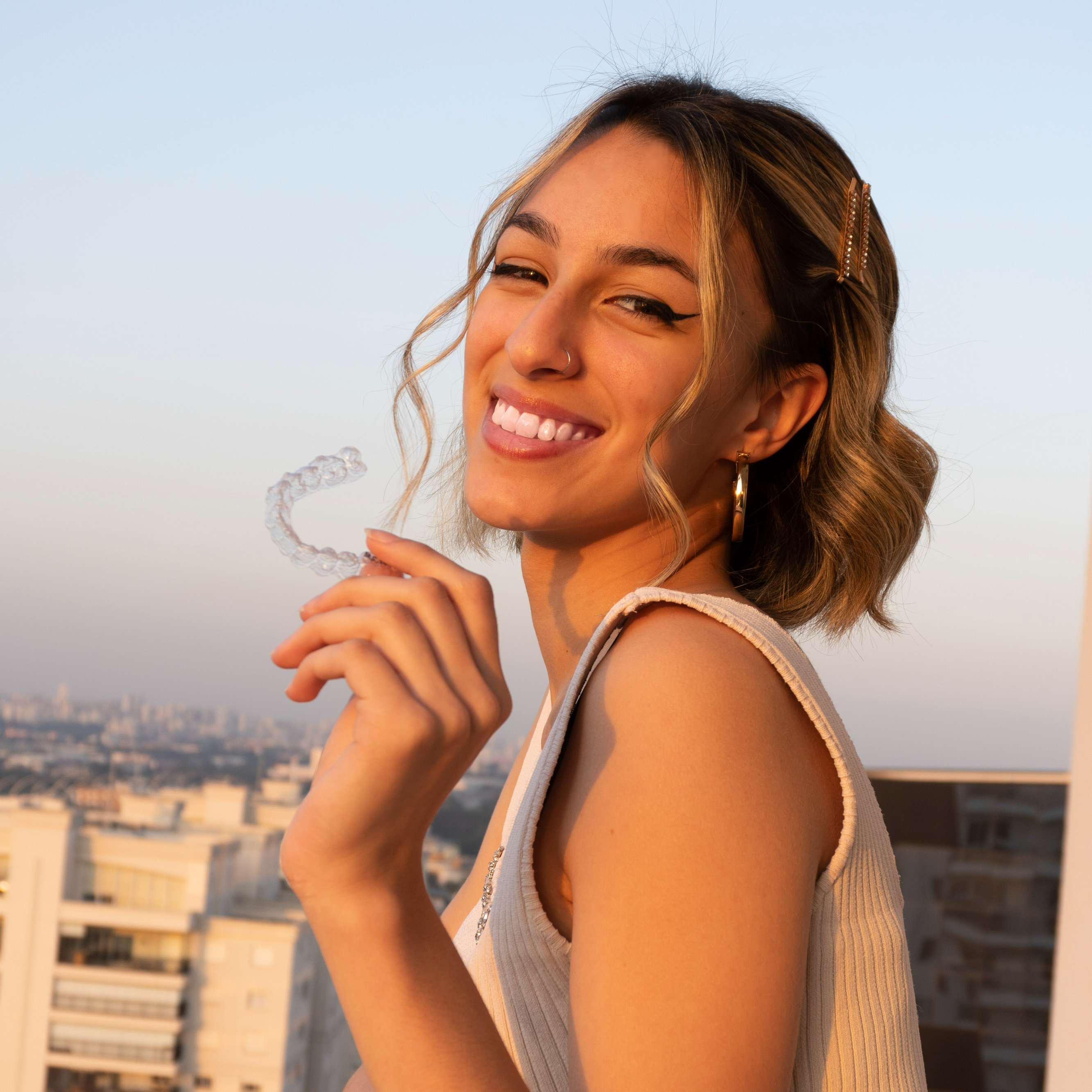 Mulher fazendo sinal de paz e amor, representando o cuidado com o sorriso